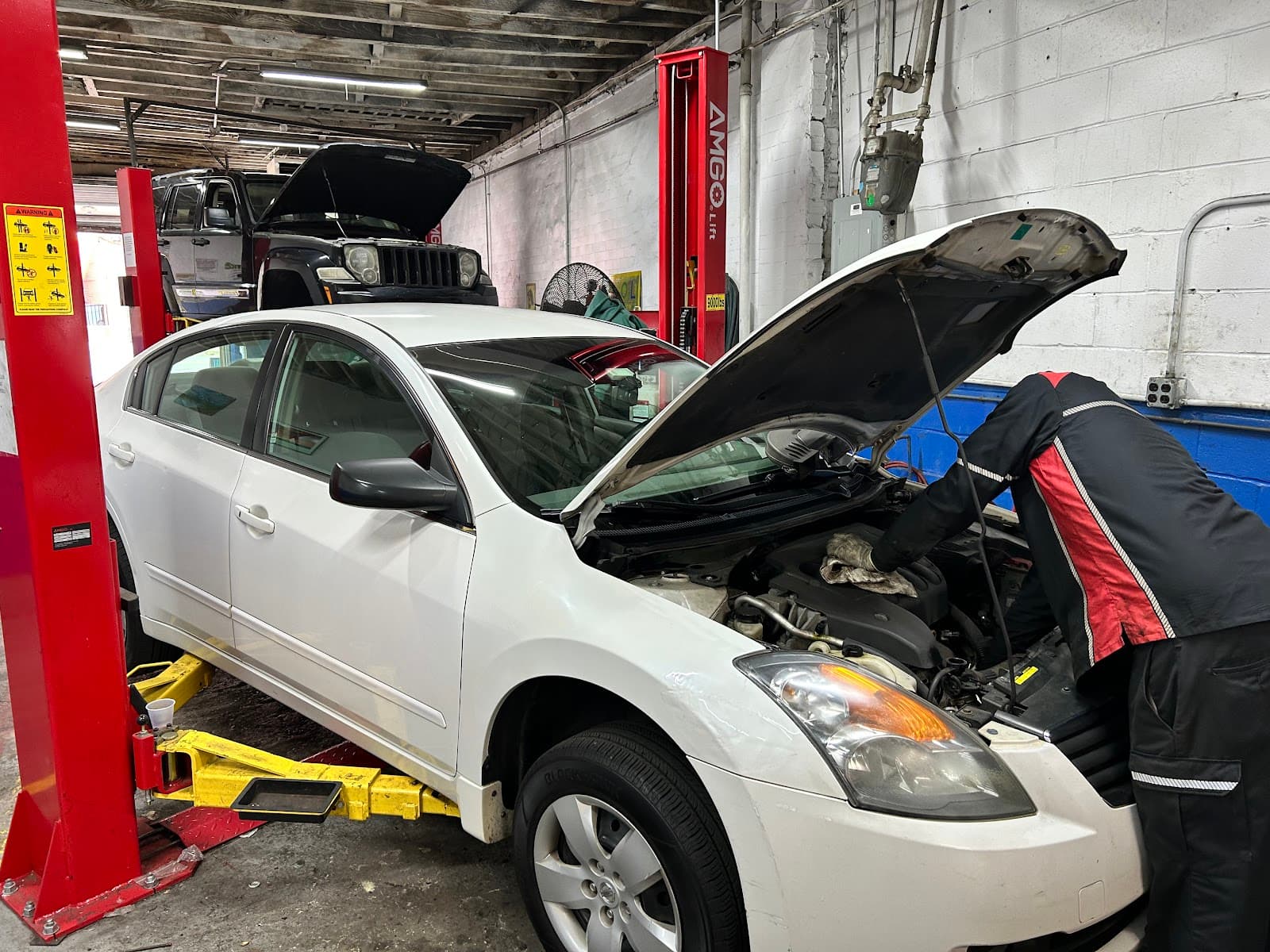 Nissan Altima with hood up on the lift
